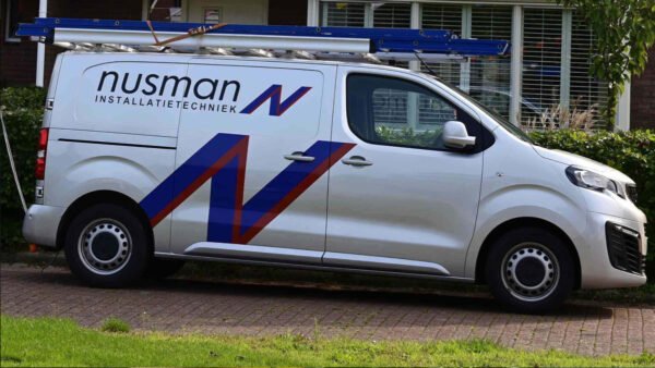 Een bus met de opdruk Nusman installatietechniek parkeert voor een woonhuis.