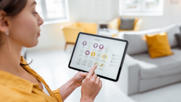 Vrouw bedient moderne domotica-systeem met tablet voor slimme elektrotechnische installatie van Nusman Installatietechniek Groningen.