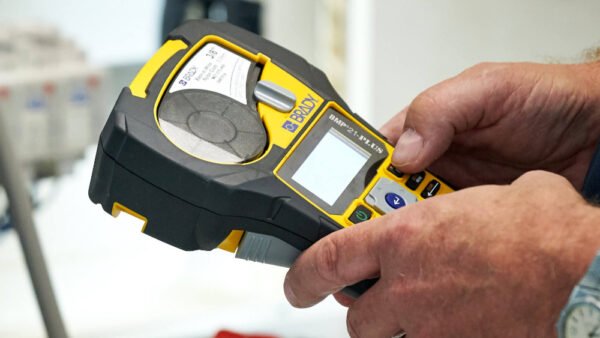 Een hand houdt een handheld apparaat vast, gekleurd in geel en zwart