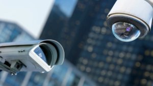 Close-up van twee beveiligingscamera's, gericht op hun lenzen en bevestigingsbeugels