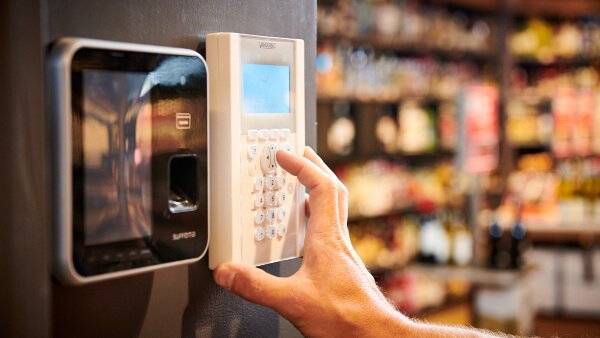 Hand die een pincode intoetst op een elektronisch toegangscontrolesysteem, aangelegd en onderhouden door Nusman Installatietechniek.