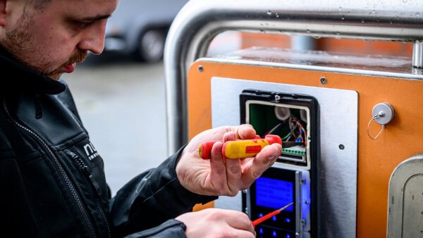 Technicus van Nusman Installatietechniek Groningen die onderhoud uitvoert aan een elektronisch toegangs- of beveiligingssysteem.