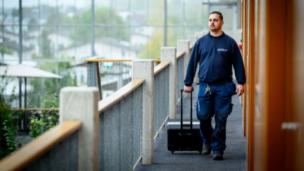 Onderhoudsspecialist van Nusman Installatietechniek Groningen die met gereedschapskoffer door een gebouw loopt voor gepland onderhoud.