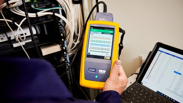 Specialist van Nusman Installatietechniek Groningen die een CAI‑ en kabeltelevisie‑installatie test en certificeert.