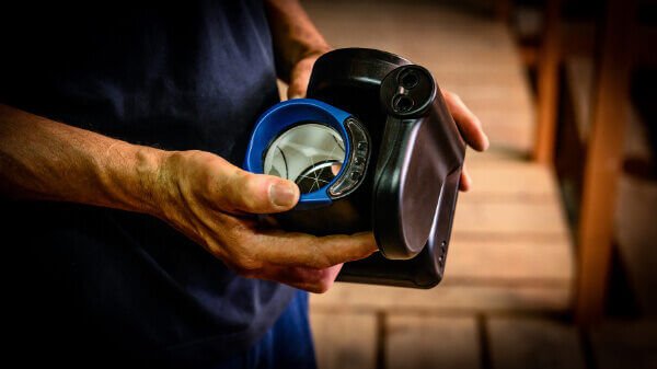 Specialist van Nusman B.V. inspecteert en test optische branddetectie-apparatuur voor een bedrijfspand.